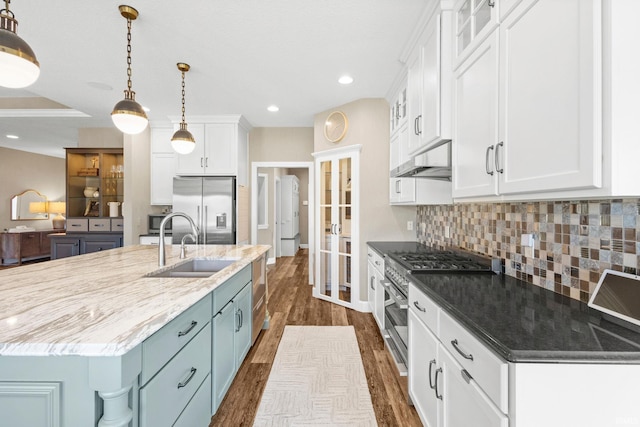 kitchen with a sink, white cabinetry, appliances with stainless steel finishes, and under cabinet range hood