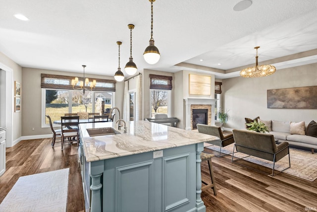 kitchen with dark wood-type flooring, a notable chandelier, open floor plan, and a sink