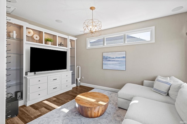 living area with baseboards, a notable chandelier, and dark wood-style flooring