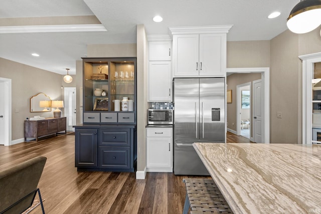 kitchen with dark wood-type flooring, backsplash, white cabinetry, recessed lighting, and stainless steel appliances