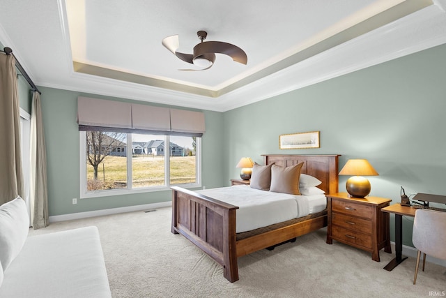 bedroom featuring crown molding, baseboards, light colored carpet, a tray ceiling, and a ceiling fan