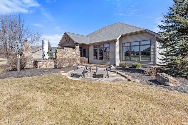 back of property featuring a patio area, a lawn, and a shingled roof