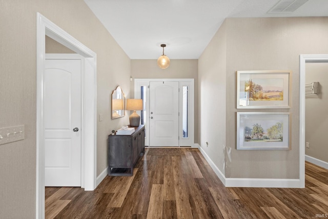 entryway with dark wood finished floors, baseboards, and visible vents