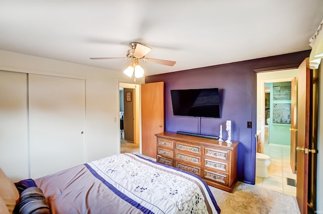 bedroom featuring a closet, light colored carpet, and a ceiling fan