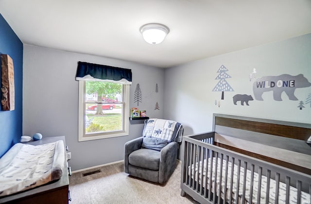 bedroom with carpet flooring, a crib, baseboards, and visible vents