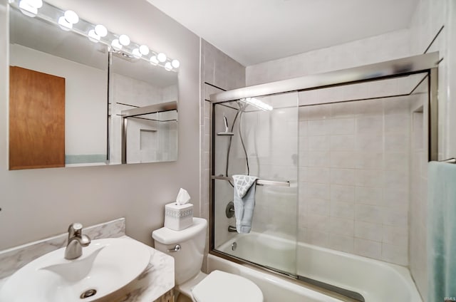 bathroom with toilet, vanity, and bath / shower combo with glass door