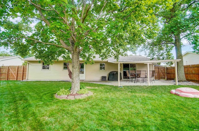 back of house featuring a patio, a yard, and a fenced backyard