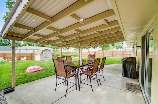 view of patio / terrace featuring a storage shed, outdoor dining area, an outbuilding, and a fenced backyard