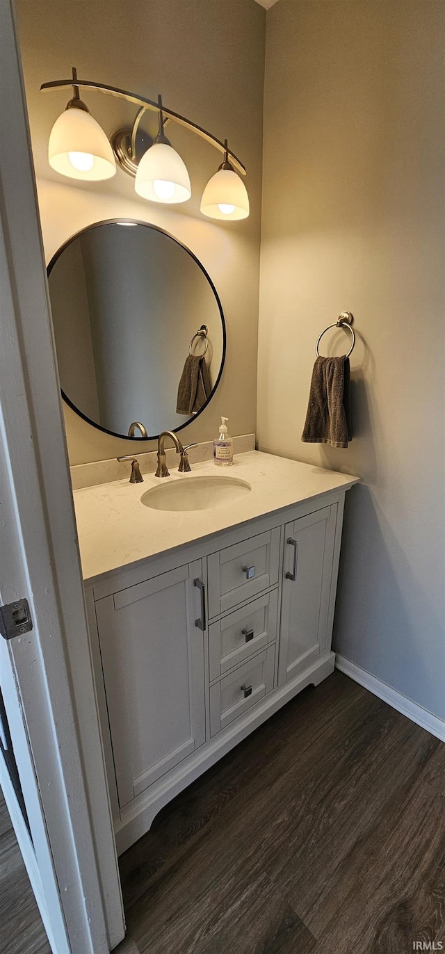 bathroom with vanity, baseboards, and wood finished floors