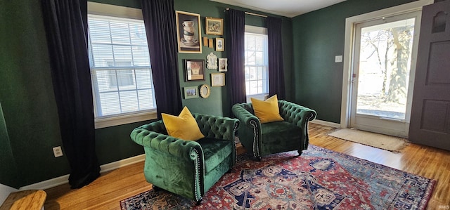 sitting room with baseboards and wood finished floors