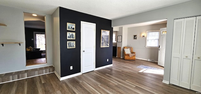 interior space featuring visible vents, baseboards, a textured ceiling, and wood finished floors