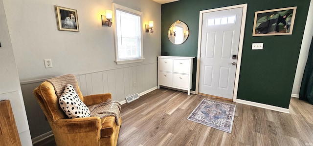 foyer with a wealth of natural light, visible vents, and wood finished floors