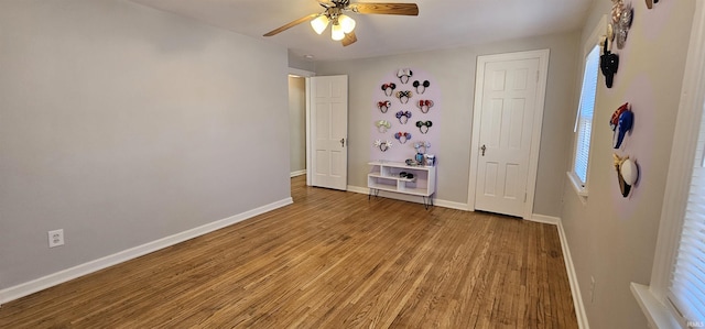 unfurnished bedroom featuring ceiling fan, baseboards, and wood finished floors