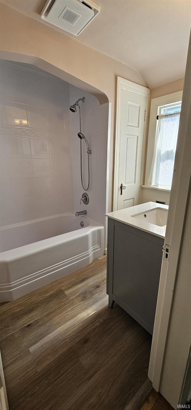 full bathroom with tub / shower combination, visible vents, wood finished floors, and vanity