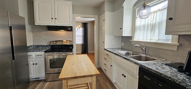 kitchen with wooden counters, a sink, stainless steel appliances, extractor fan, and white cabinets