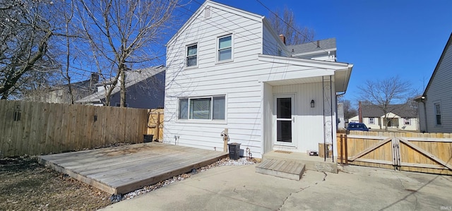 back of house with a deck, a gate, and fence