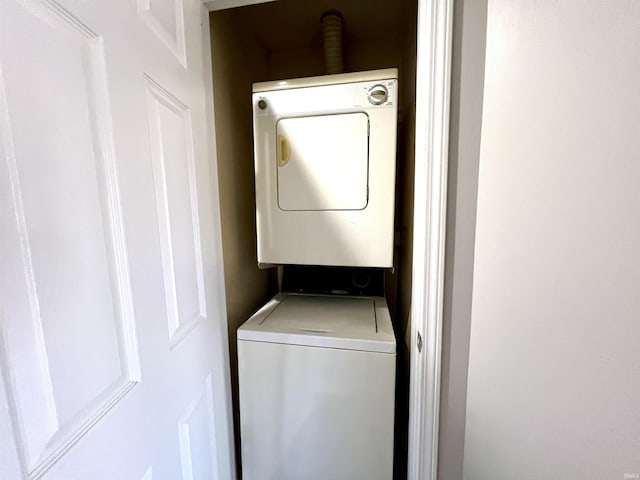 washroom with stacked washer and clothes dryer and laundry area