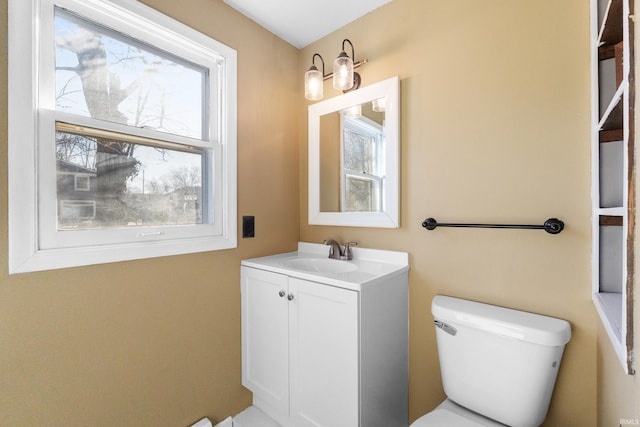 half bath with plenty of natural light, toilet, and vanity