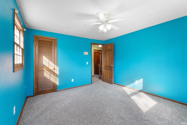 unfurnished bedroom with baseboards, carpet floors, and a ceiling fan