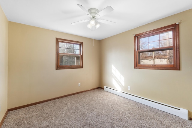 carpeted spare room featuring a baseboard heating unit, baseboards, and ceiling fan