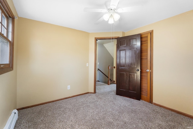 unfurnished bedroom featuring ceiling fan, baseboards, carpet floors, baseboard heating, and a closet