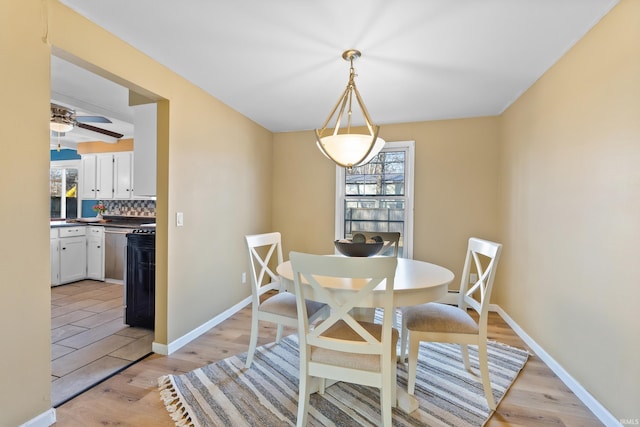 dining room with a healthy amount of sunlight, light wood-style flooring, and baseboards