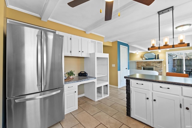 kitchen with beamed ceiling, freestanding refrigerator, white cabinets, light tile patterned floors, and ceiling fan