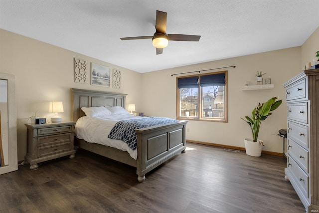 bedroom with visible vents, a ceiling fan, dark wood-type flooring, and baseboards