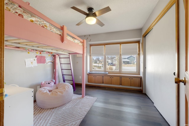 bedroom featuring ceiling fan, visible vents, a textured ceiling, and wood finished floors