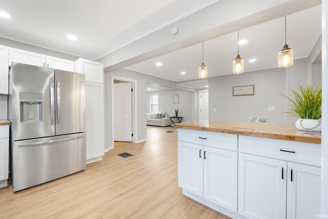 kitchen featuring recessed lighting, light wood-style floors, stainless steel refrigerator with ice dispenser, hanging light fixtures, and white cabinetry