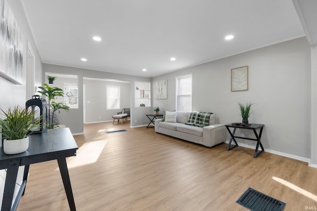 living area featuring light wood-style flooring, recessed lighting, baseboards, and visible vents