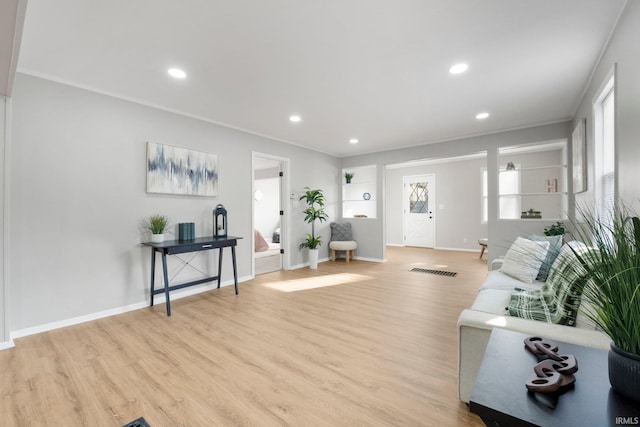 living room featuring recessed lighting, light wood-style floors, and ornamental molding