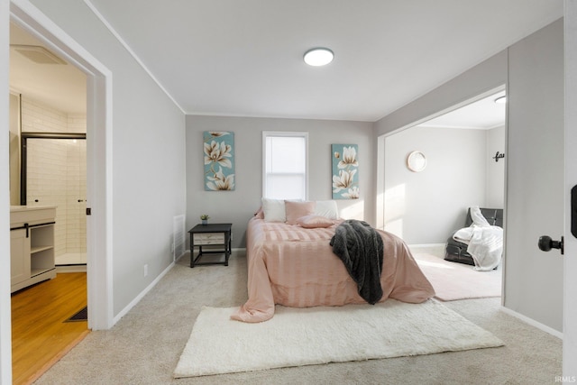 bedroom featuring baseboards, ensuite bath, and carpet