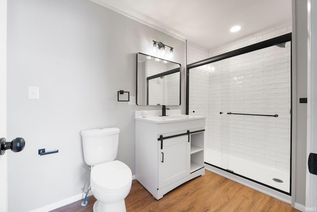 full bathroom with vanity, a shower stall, toilet, and wood finished floors