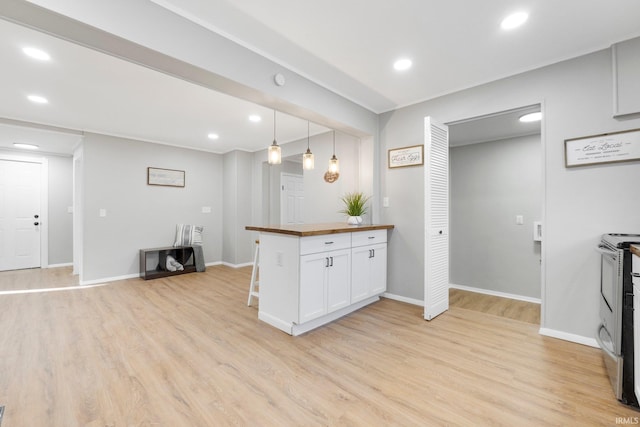 kitchen with butcher block counters, recessed lighting, light wood-style flooring, stainless steel range with electric cooktop, and white cabinets