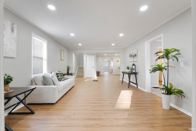 living area with recessed lighting, ornamental molding, stairs, and light wood finished floors