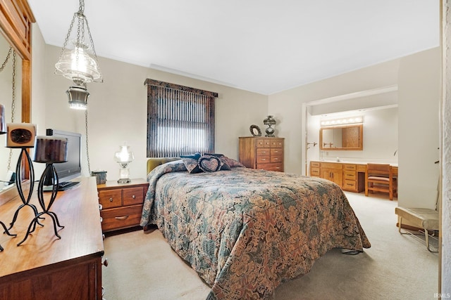 bedroom with connected bathroom and light carpet