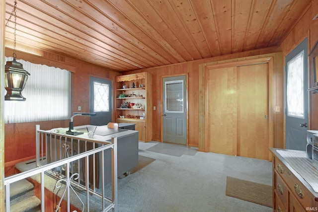 office featuring light carpet, wood ceiling, and wood walls