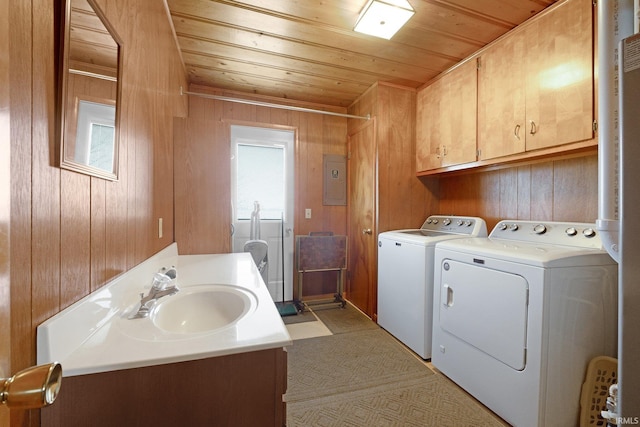 washroom with a sink, washer and dryer, wood walls, wood ceiling, and laundry area