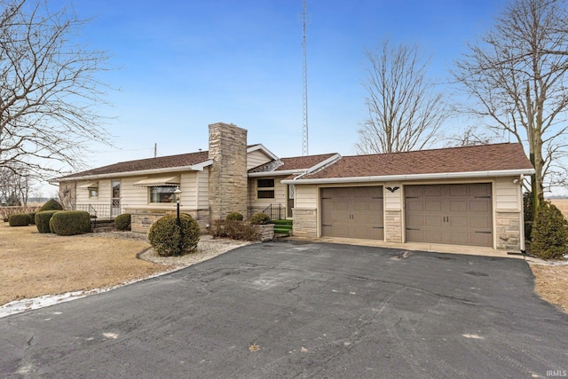 single story home featuring stone siding, a detached garage, and a chimney