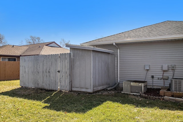 exterior space with central air condition unit, a lawn, and fence