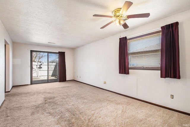 unfurnished room featuring baseboards, carpet, a ceiling fan, and a textured ceiling