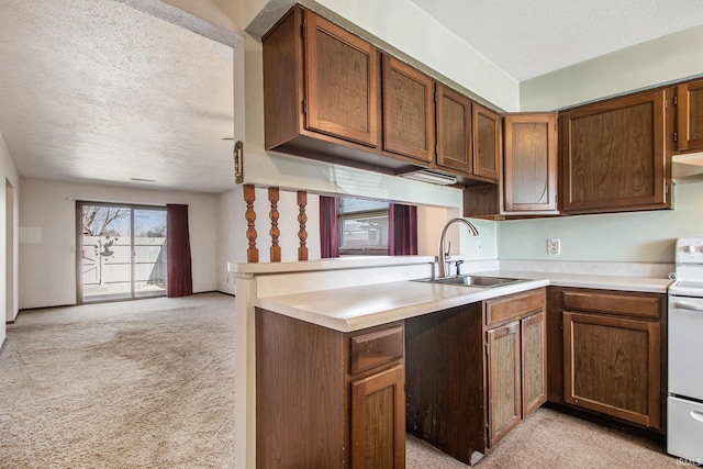 kitchen with light countertops, light carpet, a textured ceiling, white electric range, and a sink