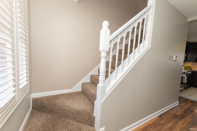 stairway featuring baseboards and wood finished floors