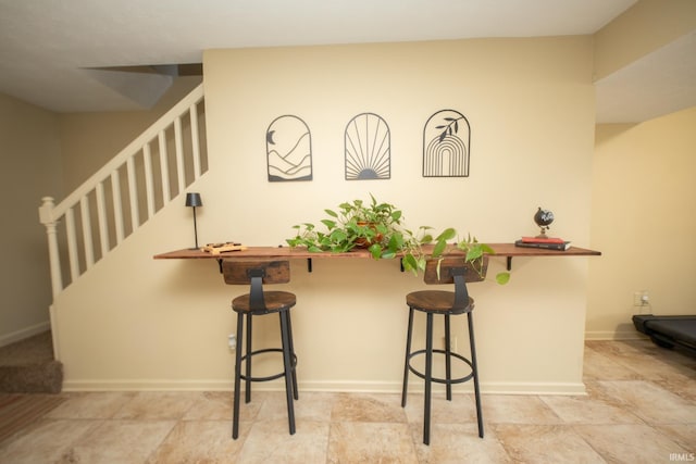 interior space with baseboards and a breakfast bar