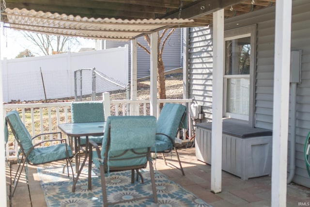 view of patio featuring outdoor dining space and fence