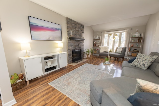 living room featuring a fireplace, lofted ceiling, and wood finished floors