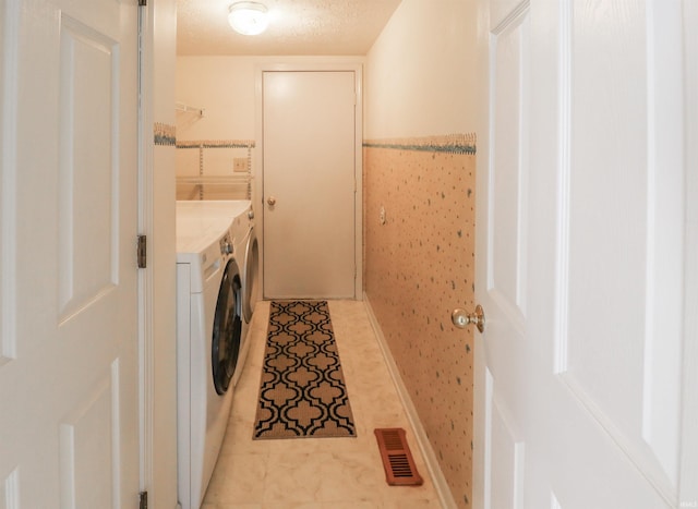 washroom featuring visible vents, light tile patterned floors, laundry area, a textured ceiling, and separate washer and dryer