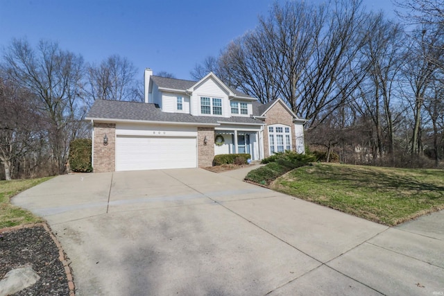 traditional home with a front yard, driveway, an attached garage, a chimney, and brick siding