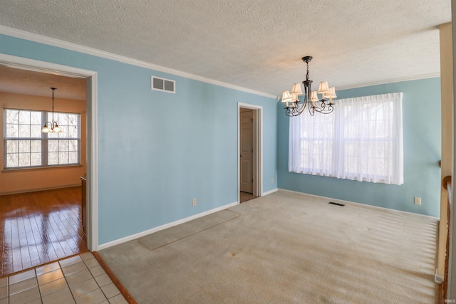 empty room with visible vents, a textured ceiling, an inviting chandelier, and crown molding